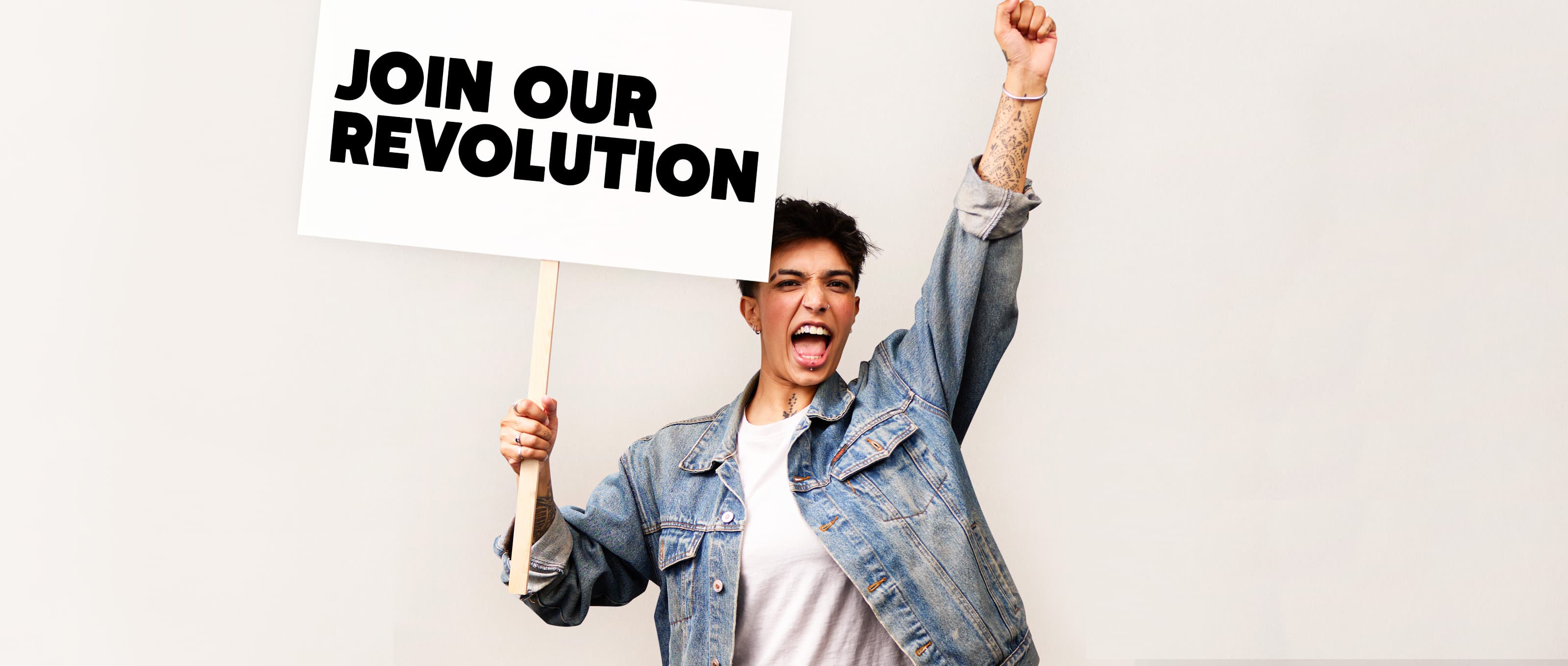Person holding up a placard sign which reads "Join Our Revolution