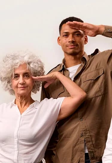 Two people stand side by side, both saluting. An older woman with curly gray hair and a younger man in a brown shirt.